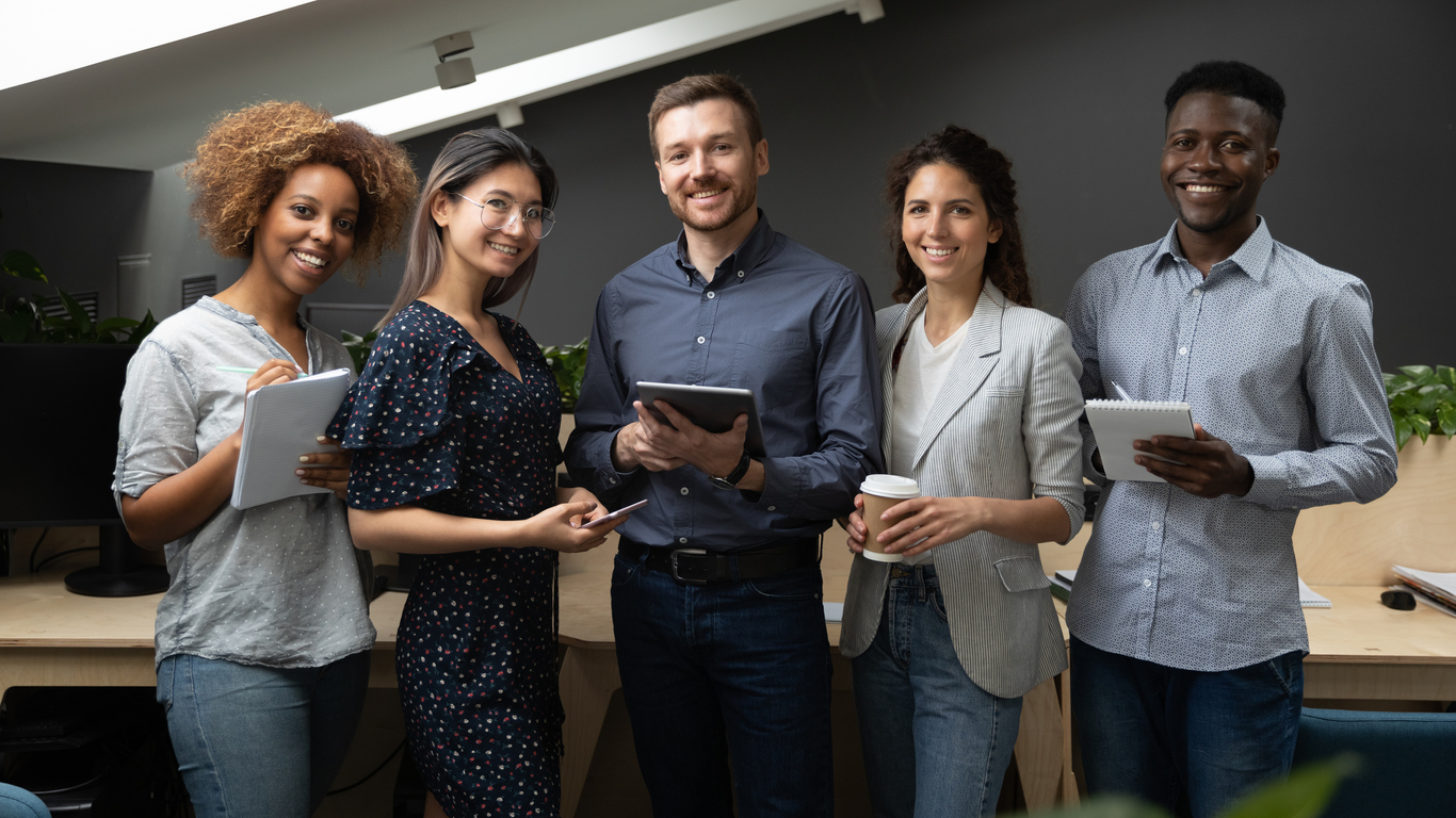 Retrato em grupo de equipe multiétnica sorridente posando no escritório